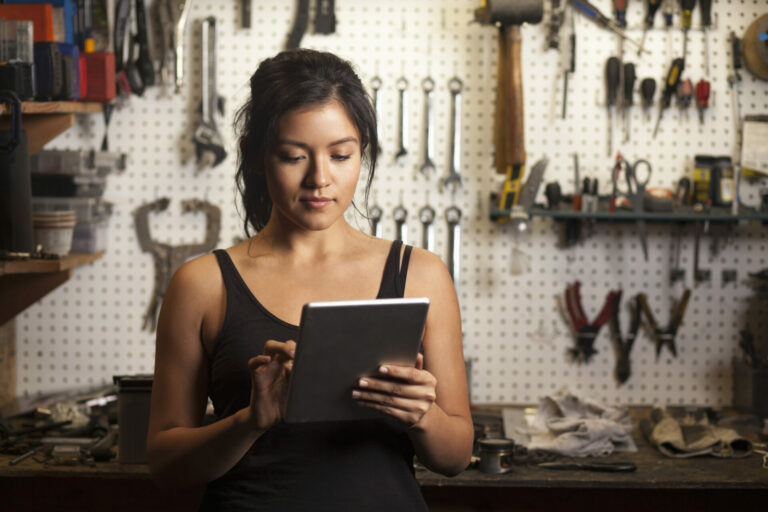 Female mechanic in workshop, using digital tablet